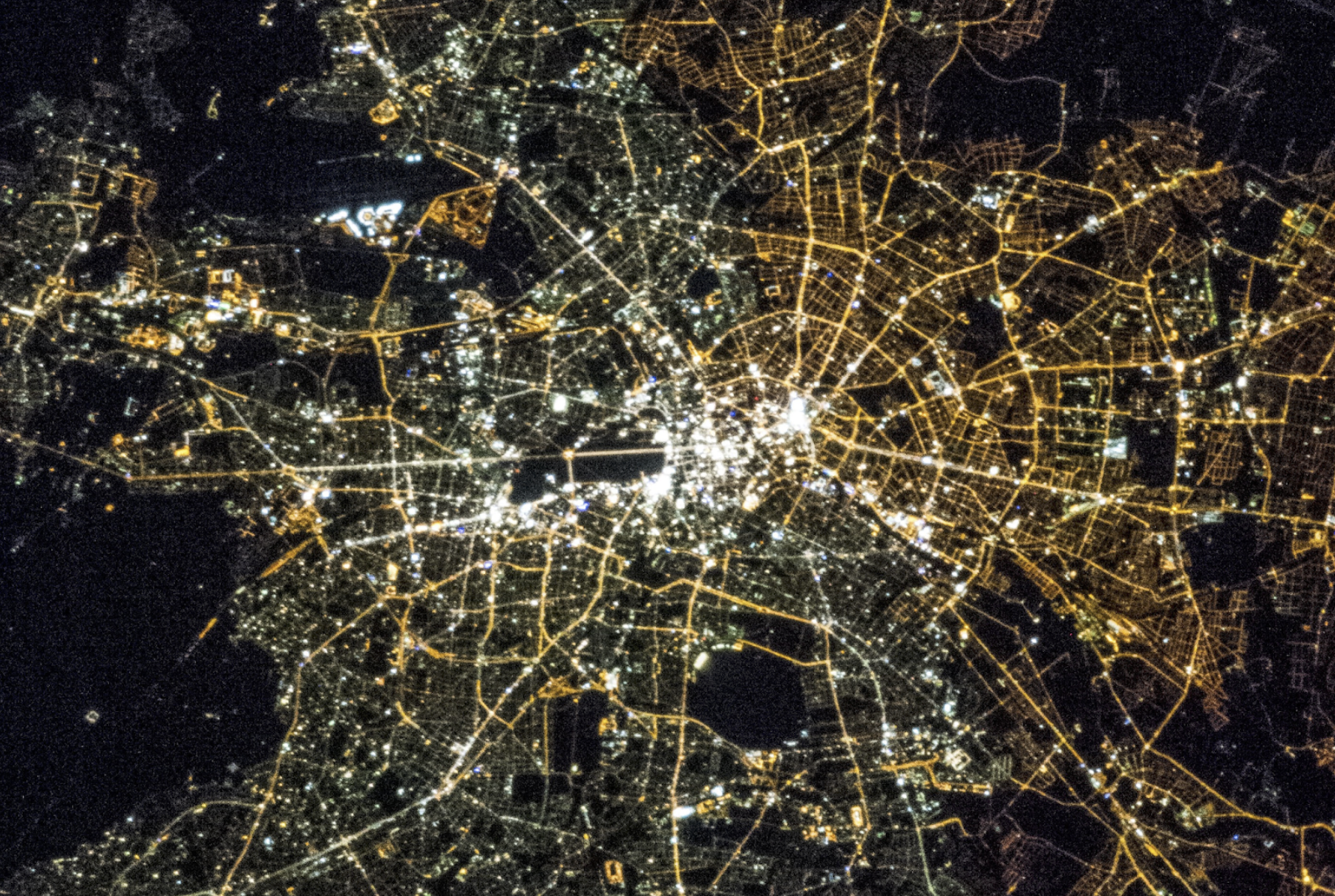 Night satellite view of a dense, brightly lit city centre